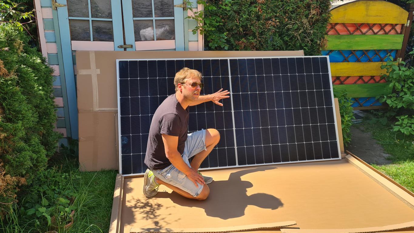 Das Yuma Flat XL Solarmodul steht angelehnt an ein Gartenhäuschen und der Smart-Home-Fox Experte zeigt im Test drauf und erzählt von seinen Erfahrungen.